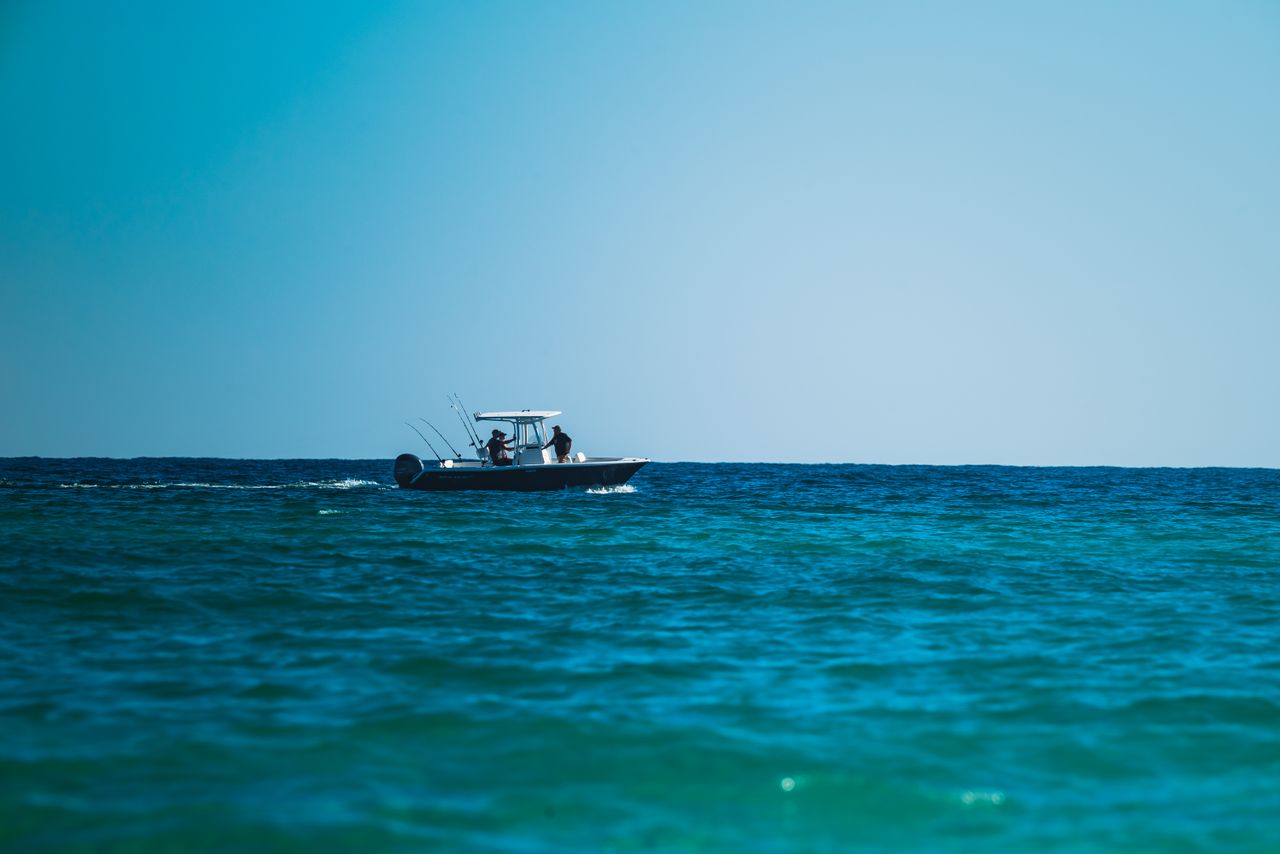 Center-console boat running offshore on deep blue water — Florida mahi-mahi fishing