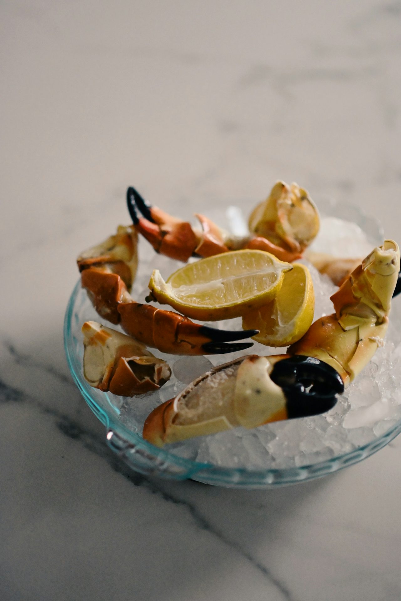 Fresh Florida stone crab claws served on ice with lemon wedges